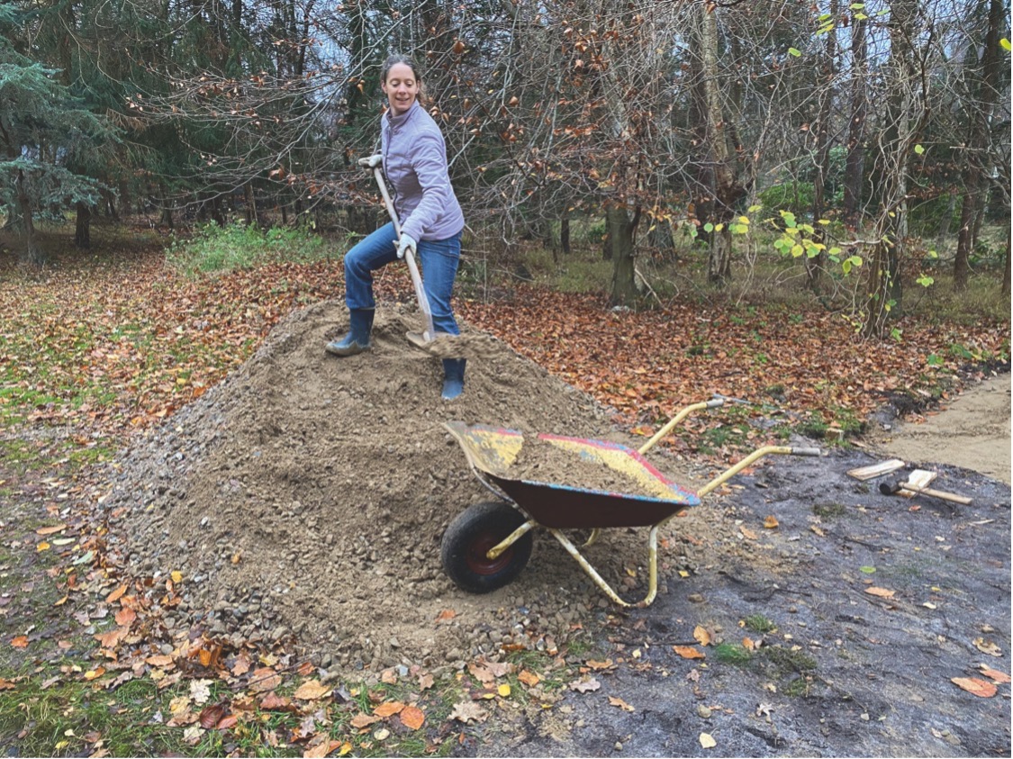 Grus skovlen i trillebøren og fordeles ud på petanquebanen Foto: Charlotte Brix Andersen