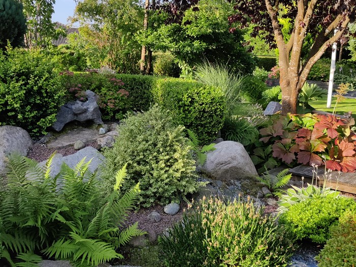 Havedesign med store sten, terrasser og bede