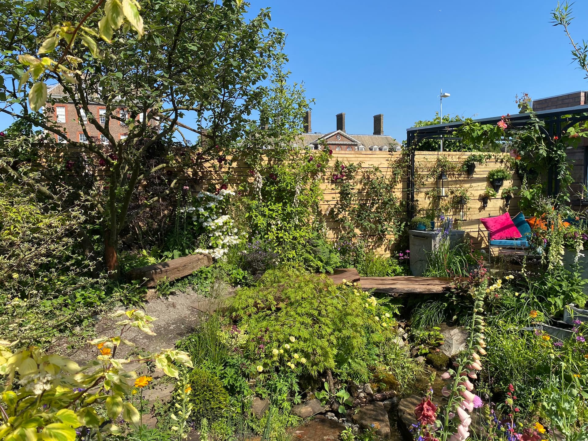 I skyggen under æbletræet kan man sætte sig og tage et hvil og skue ud over haven. Foto: Haveselskabet