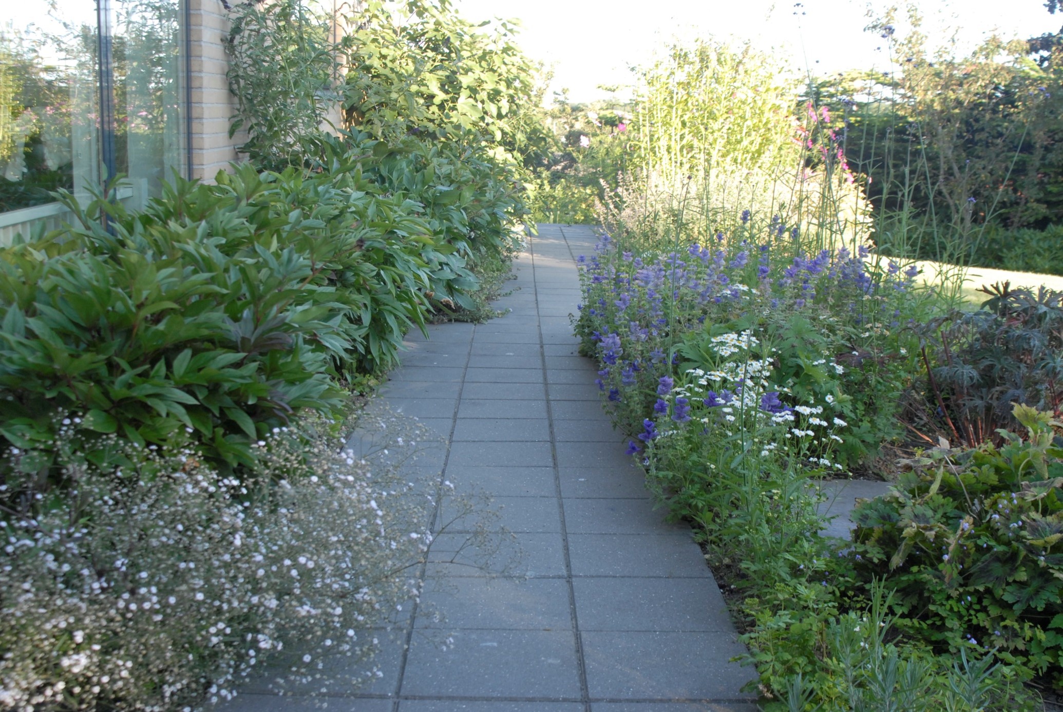 Flisestier med store fliser giver færre fuger og dermed mindre arbejde med at rense for ukrudt dér