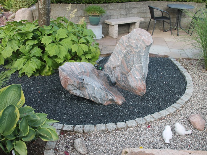 Havedesign med sten, træer, buske, terrasser og bede