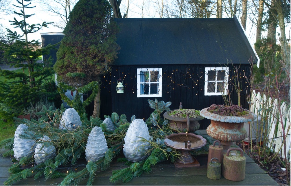 Anette Krogh Pedersens have (også kendt som Fru Pedersens have) er pyntet med nordmannsgran og rustikke grene fra et væltet grantræ. Heriblandt er sat forvoksede lysegrå grankogler støbt i beton. Foto: Ann Malmgren