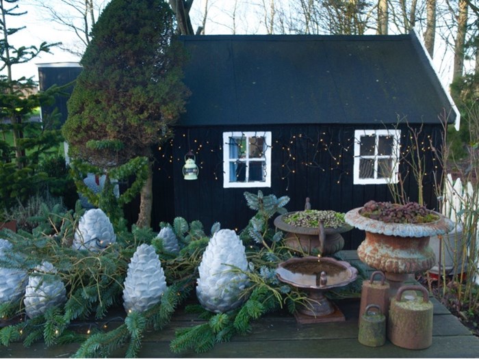 Anette Krogh Pedersens have (også kendt som Fru Pedersens have) er pyntet med nordmannsgran og rustikke grene fra et væltet grantræ. Heriblandt er sat forvoksede lysegrå grankogler støbt i beton. Foto: Ann Malmgren