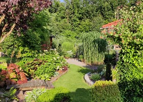 Havedesign med sten, træer, buske, terrasser og bede