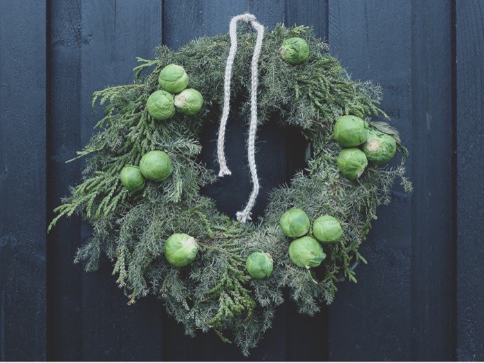 Krans af kransecypres, Chamaecyparis pisifera ‘Squarrosa’, og hønsebenstræ, Thujopsis dolabrata, viklet om en færdig grankrans og pyntet med rosenkål. Foto: Karina Emilie Revsbæk Lauesen